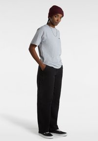 Grijze korte mouwen t-shirt, zwarte cargobroek met zakken, zwarte sneakers en een bordeauxrode gebreide beanie. Eenvoudig, casual ontwerp met een ontspannen pasvorm.