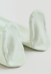 Moufles blanches douces pour bébé en tissu coton, conçues pour couvrir et protéger les mains des nourrissons.