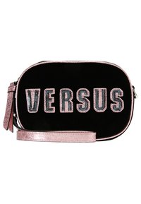 Bolso bandolera ovalado negro con ribete y correa metálicos rosas, con la palabra "VERSUS" en letras de lentejuelas rosas y negras en la parte delantera.