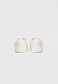 Tenisi albi cu un interior din piele netedă, vârf rotunjit, călcâi căptușit și design minimalist. Talpa este plată și din cauciuc.