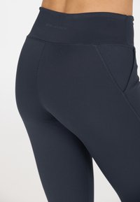 Marina blå leggings tillverkade av stretchigt, slätt tyg, med en hög midja och platta sömmar för komfort och minskad skav.