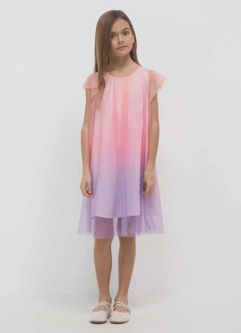 Rosa-lila Farbverlauf Tüllkleid mit kurzen Rüschenärmeln, glitzernder Textur und schmalem Knieabschluss. Kombiniert mit hellen Schuhen.