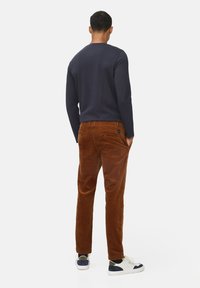 Navy lange mouwen overhemd, gecombineerd met bruine corduroy broek. Heeft een slim fit, een gladde textuur, en witte sneakers met navy accenten.