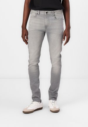 Gray denim jeans with a slim fit, five-pocket design, subtle fading, and a button closure, paired with white sneakers.