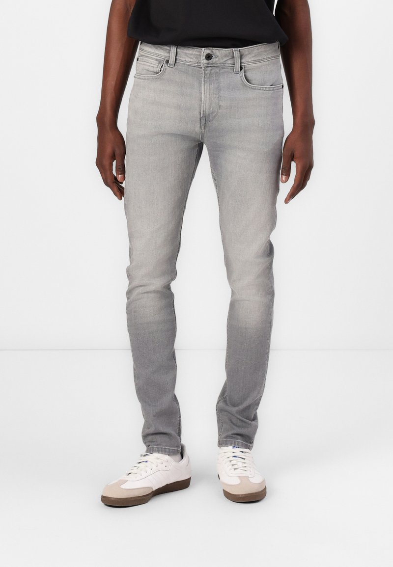 Gray denim jeans with a slim fit, five-pocket design, subtle fading, and a button closure, paired with white sneakers.