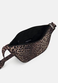 Geantă din material cu imprimeu leopard, cu un fermoar deschis care arată interiorul negru și un buzunar interior cu fermoar cu eticheta "PIECES."