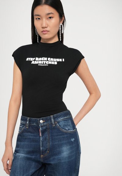 Bodysuit negro ajustado con cuello alto y mangas cortas, que presenta un atrevido texto blanco. Combinado con jeans de mezclilla desgastados en azul claro.