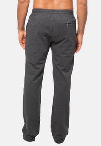 Grijze joggingsbroek met een Relaxed fit, elastische tailleband en een achterzak. De stof lijkt zacht met een gladde textuur en subtiele draping.