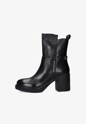 Stivaletto in pelle nera con punta arrotondata, piattaforma spessa e tacco a blocco. Presenta una fibbia laterale e un pratico pull tab sulla parte superiore.