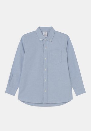 Lichtblauw overhemd met lange mouwen, knopen, een button-down kraag en borstzak, plat gelegd op een witte achtergrond.