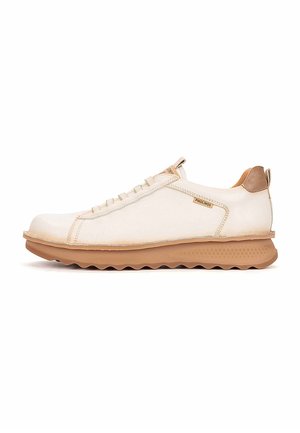Zapatilla deportiva beige de piel de corte bajo con suela marrón y lengüeta en el talón, cierre con cordones y etiqueta de la marca en el lateral.