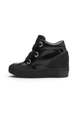 Sneaker nera alta con tacco a zeppa, finitura lucida, lacci neri spessi e occhielli d’argento su sfondo bianco.