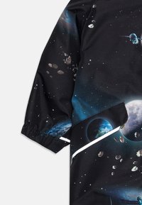 Zwarte stof met een ruimte-thema ontwerp met planeten, asteroïden en sterren; bevat een elastische manchette en contrasterende witte afwerking.