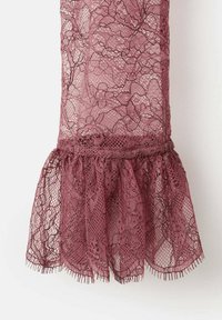 Vestido de encaje burdeos con intrincados patrones florales y un dobladillo con volantes. La tela tiene una textura delicada y transparente con un borde deshilachado.