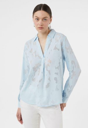 Hellblaues Langarmhemd mit kragenförmigem Ausschnitt, aus einem transparenten Stoff mit einem abstrakten Texturmuster. Weißer Hintergrund.