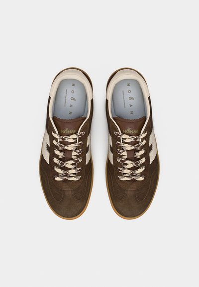 Ζευγάρι καφέ σουέντ αθλητικά παπούτσια με κρεμ κορδόνια και πλαϊνές ρίγες, σε θέα από πάνω σε απλό λευκό φόντο.