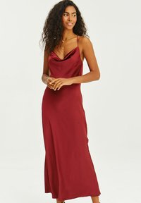 Burgundské saténové slip šaty s oválnym výstrihom, úzkymi ramienkami a voľným strihom. Hladká textúra a dĺžka po zem.