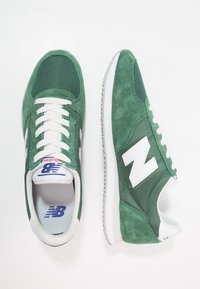 Gröna mocka- och mesh-sneakers med vita accenter, med en strukturerad yta, traditionell snörning och gummisula.