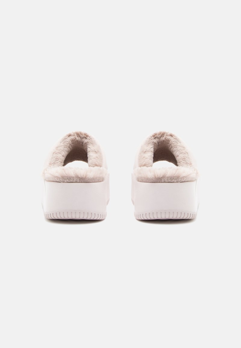 Pantofole morbide e beige con suola in gomma bianca, dotate di una comoda fodera interna e design con tallone aperto per una facile vestibilità.