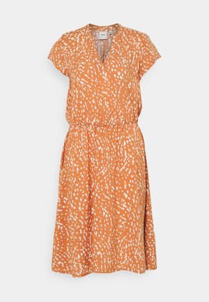 Robe orange avec un décolleté en V, des manches courtes et une taille élastique. Présente un motif blanc tacheté et une silhouette évasée arrivant au genou.