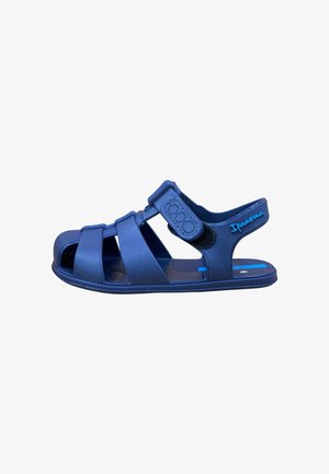 Sandalo da bambino blu con cinturino in velcro regolabile e punta chiusa, marchiato "Ipanema" sulla fascetta del tallone.
