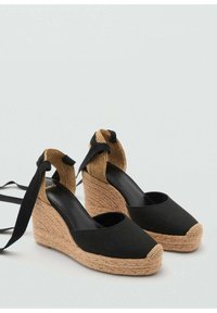 Schwarze Canvas-Espadrilles mit Wedge-Absatz und geflochtener Jutesohle, ausgestattet mit schwarzen Stoffriemen und einem strukturierten, tanfarbenen Akzent an der Ferse.