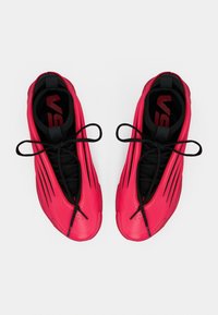 Scarpe da ginnastica di un rosa vivace con lacci neri e fodera interna nera, viste dall'alto su sfondo bianco.