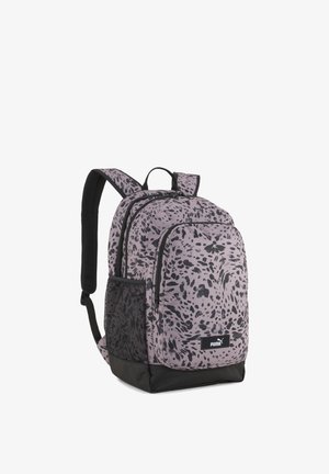 Sac à dos Puma à motifs violets et noirs avec deux compartiments zippés, poche latérale en mesh, bretelles rembourrées et base noire.