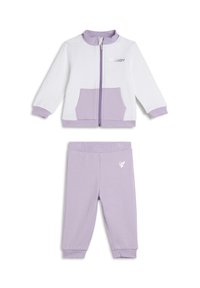 Conjunto de chándal en tono púrpura claro que incluye una chaqueta con cremallera, detalles en blanco y un bolsillo frontal, combinado con pantalones a juego y detalle de logo.
