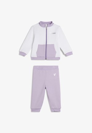 Conjunto de chándal en tono púrpura claro que incluye una chaqueta con cremallera, detalles en blanco y un bolsillo frontal, combinado con pantalones a juego y detalle de logo.
