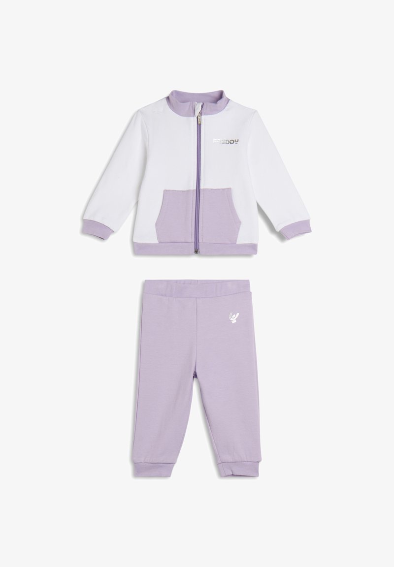 Conjunto de chándal en tono púrpura claro que incluye una chaqueta con cremallera, detalles en blanco y un bolsillo frontal, combinado con pantalones a juego y detalle de logo.