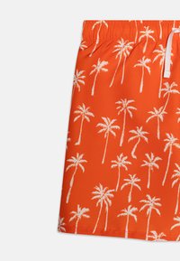 Shorts de bain orange en matériau léger, ornés d'un motif de palmiers blancs, avec une taille élastique et un cordon de serrage.
