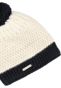 Stickad mössa i krämfärgad och marinblå, med en texturerad kropp, ribbad skärm och en svart pom-pom på toppen; inkluderar en metall-logotypetikett.