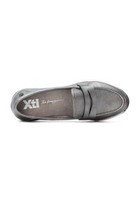 Zapato gris de cuero tipo slip-on con suela plana, que presenta dos correas decorativas y una superficie lisa y texturizada. En el interior tiene una plantilla con la marca.