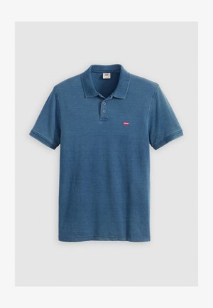Zils kokvilnas polo krekls ar īsām piedurknēm, trīs pogu aizdari un sarkanu Levi's logotipu kreisajā krūtī. Gluda tekstūra ar ikdienišķu piegriezumu.