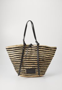 Woven tote bag featuring black and beige striped straw material, with black leather straps and a metallic logo plate on the front.