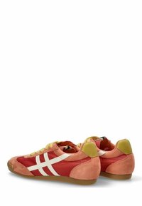 Zapatillas de ante rojas y melocotón con acentos en blanco, lados de malla y un talón verde. Presentan una punta redondeada y suela de goma plana.