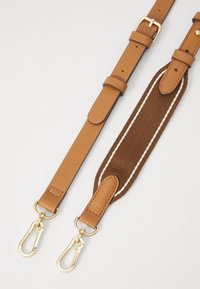 Cinturino in pelle marrone con superficie testurizzata e hardware dorato, che presenta una sezione in tessuto imbottito con cuciture bianche per comfort e stile.