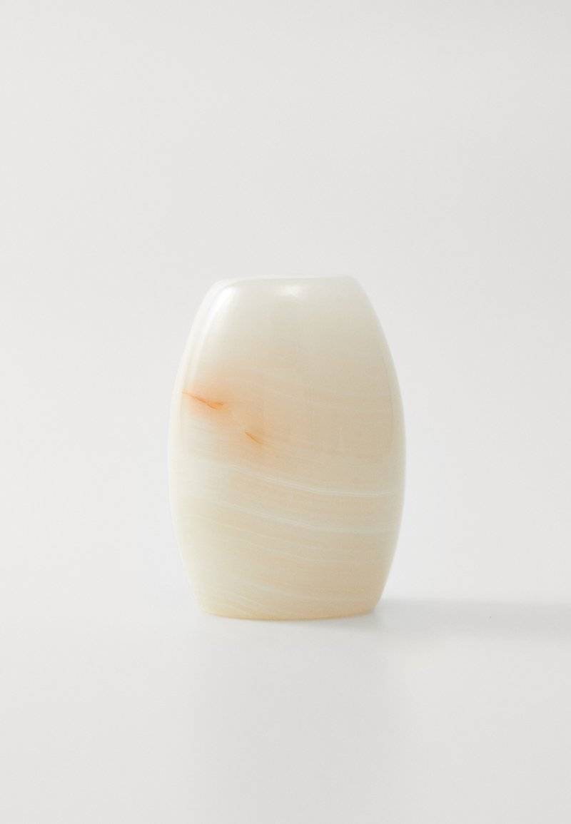 Porcelāna vāze, ovāla forma, maiga krēmkrāsa ar viegli oranžiem vēnām, gluda virsma ar spīdīgu apdari un noapaļota augšdaļa.