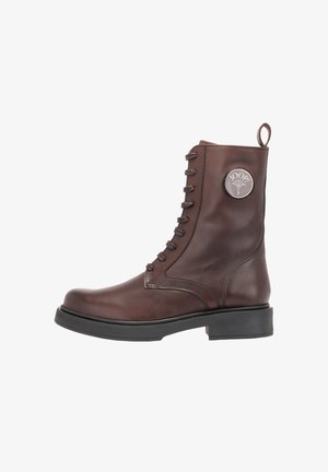Bottes montantes en cuir marron avec un bout rond, un système de laçage et une languette. Accent du logo circulaire sur le côté extérieur. Semelle épaisse noire.