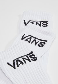 Calcetines de algodón blancos con textura acanalada y el logotipo negro "VANS" bordado en el puño. Diseño simple adecuado para uso casual.