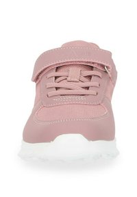 Różowy but sportowy z teksturowanym wierzchem z tkaniny, elastycznymi sznurowadłami i paskiem na rzep. Posiada białą gumową podeszwę i wzmocniony czubek.