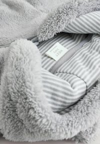 Szara kocyk dla niemowląt z miękkim, pluszowym wierzchem i paskowanym szarym wnętrzem. Posiada metkę z napisem "NEXT Baby" oraz zaokrąglone krawędzie.
