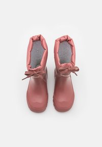 Bottes imperméables roses avec un intérieur doux en polaire, une manche élastique et un détail de laçage classique. Semelle en caoutchouc texturée pour plus d'adhérence.