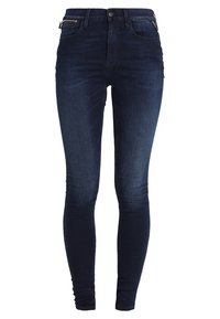 Jeans ajustados de denim en color azul oscuro. Incluyen características como cintura alta, bolsillos frontales y un cierre con cremallera y botón. Textura suave.