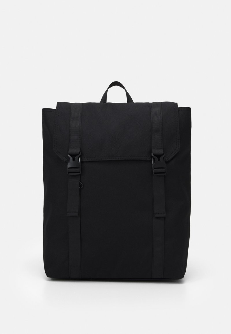 Sac à dos noir en tissu durable. Comprend une fermeture à rabat avec deux sangles réglables et une poignée supérieure. Design rectangulaire simple.