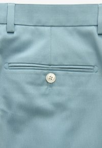 Light blue trousers with a smooth texture, featuring a single back pocket with a circular button closure and subtle stitched accents.