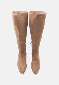 Ζευγάρι ψηλών καφέ μπότες από σουέντ με μυτερά δάχτυλα και φερμουάρ στο πλάι, από πάνω σε λευκό απλό φόντο.