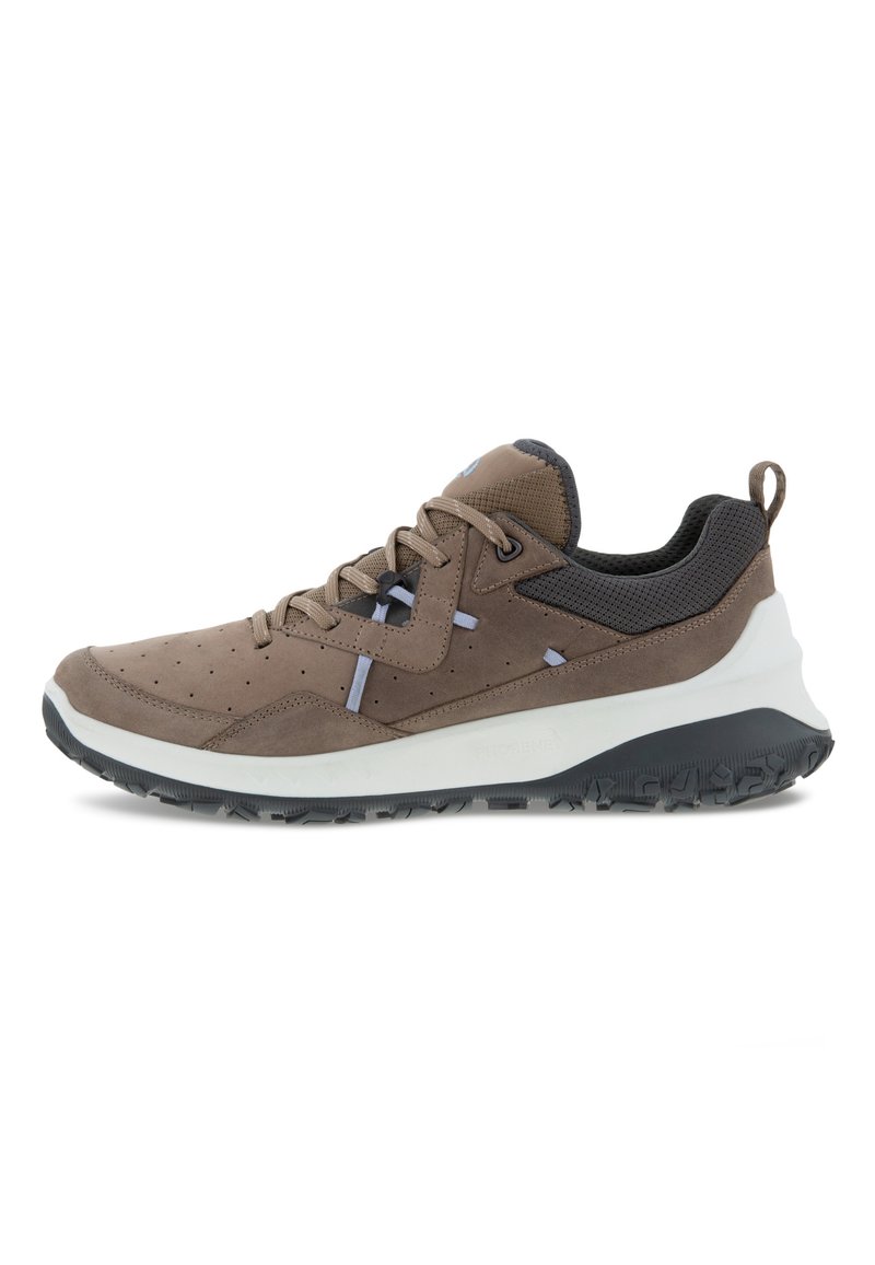 Scarpa sportiva marrone chiaro con tomaia in suede texture, dettagli in mesh e intersuola bianca. Presenta una punta arrotondata e una suola in gomma per una maggiore aderenza.