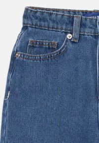 Blå denimjeans med hög midja, femfickorsdesign och kontrasterande sömmar. Tyget har en lätt textur och en klassisk passform.